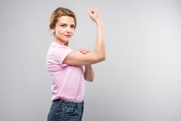 femme féministe en t-shirt rose montrant les muscles, isolé sur gris
 - Photo, image