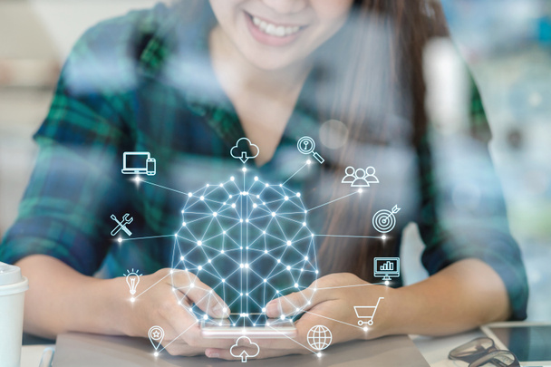 Polygonal brain shape of an artificial intelligence with various icon of smart city Internet of Things Technology over Asian businesswoman hand using the smart mobile phone,AI and business IOT concept - Photo, Image