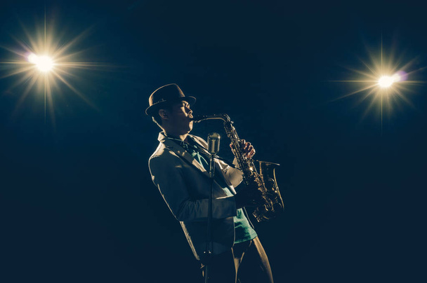 Asian Musician playing the Trumpet with spot light and lens flare on the stage, musical concept - Photo, Image