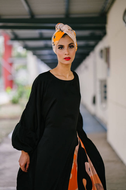 Fashion portrait of a beautiful, tall and fashionable woman of Middle Eastern descent. She is posing in city - Фото, зображення
