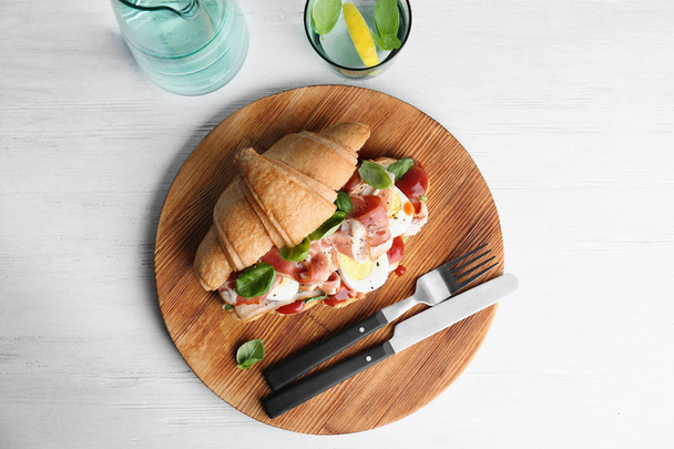 Tasty croissant sandwich with bacon on wooden background, top view - Φωτογραφία, εικόνα