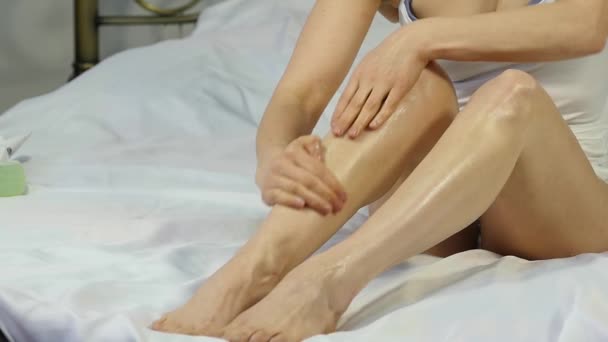 woman applying cream on her legs. foot skin care concept, prevention of varicose veins. slow motion - Video