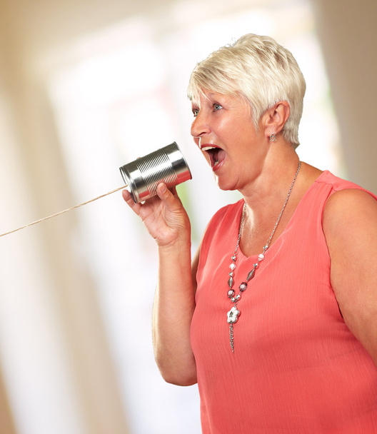 Mujer mayor hablando en lata de metal puede teléfono
 - Foto, Imagen