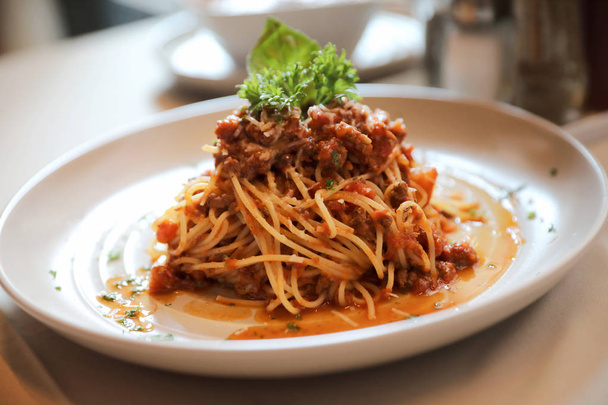 Spaghetti Bolognese mit Rinderhackfleisch und Tomatensauce garniert  - Foto, Bild