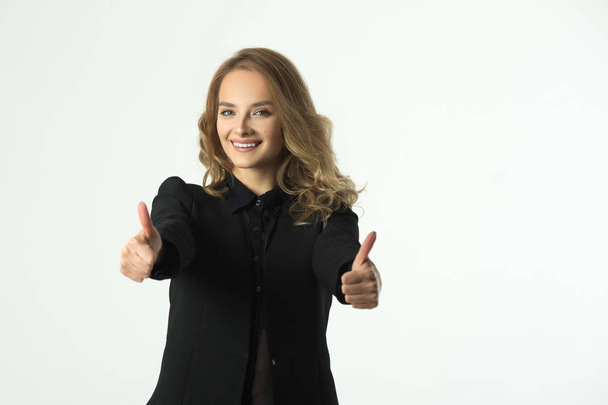 beautiful young joyful girl in a black jacket on a white background with gestures of hands - Foto, Bild