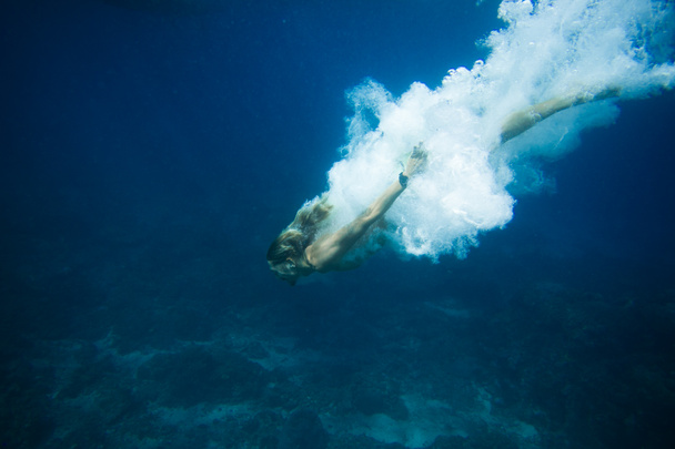 underwater pic of young man diving in ocean alone - Foto, afbeelding