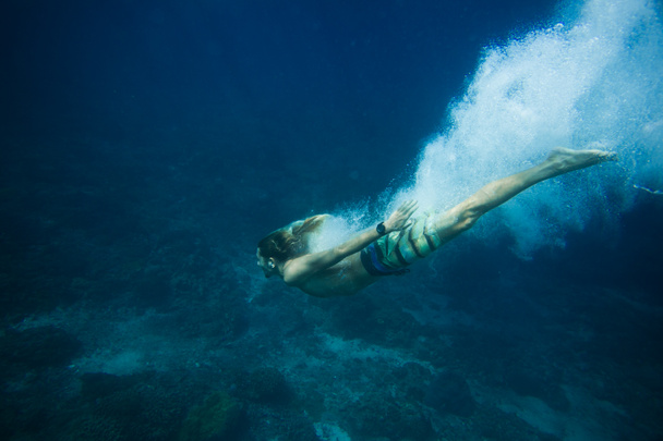 underwater pic of young man diving in ocean alone - Foto, Imagen
