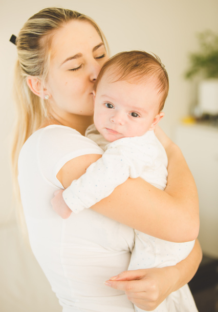 Portret szczęśliwy młoda kobieta, przytulanie i całując jej cute baby - Zdjęcie, obraz