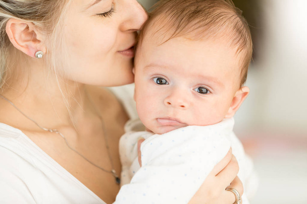 Closup portrait of young woman kissing her 3 months old baby boy - Photo, Image