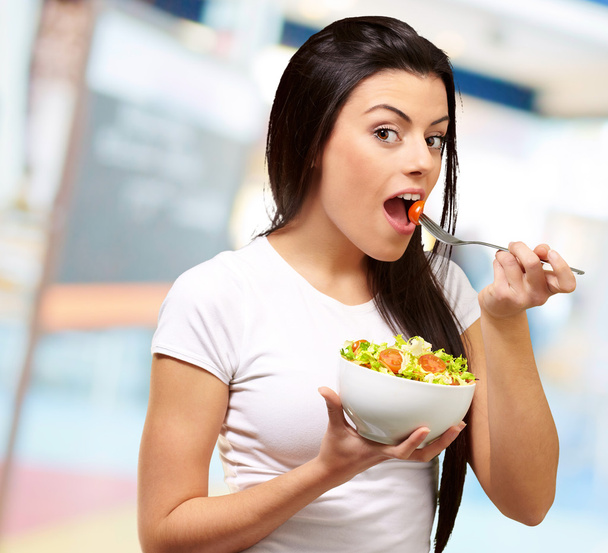 Молодая девушка ест салат из чаши
 - Фото, изображение