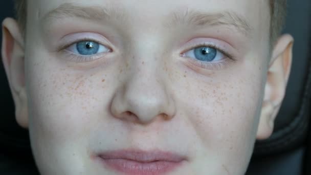 Vrolijke blonde jongen met een tiener met sproeten op zijn gezicht en blauwe ogen kijken camera en gelukkig gek - Video