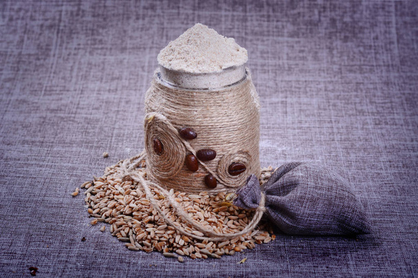 A decorative container of flour is in the grain - Foto, afbeelding