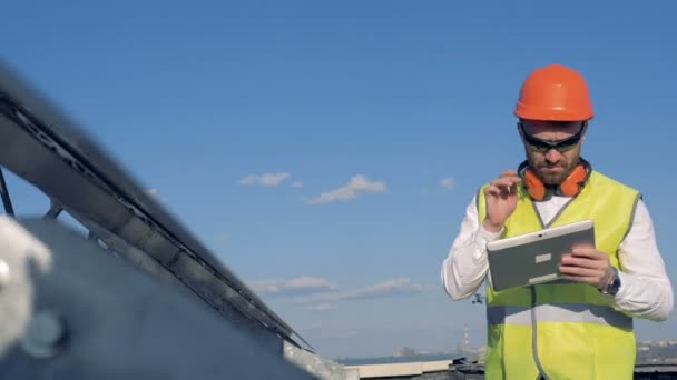 Worker looks at solar panels. - Video, Çekim