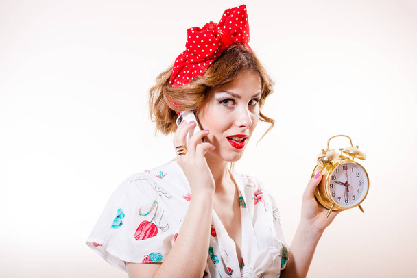 Closeup portrait of pinup woman with alarm clock on the phone - Photo, Image