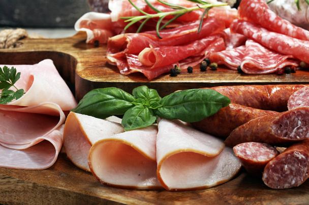 Food tray with delicious salami, ham,  fresh sausages and herbs. - Photo, Image