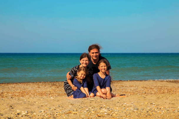 Mosolyogva a strandon, szemben a tenger családi portré.  - Fotó, kép
