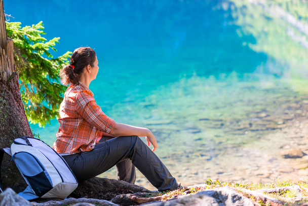 タトラ山脈の海目の湖のほとりに座っている女性、 - 写真・画像
