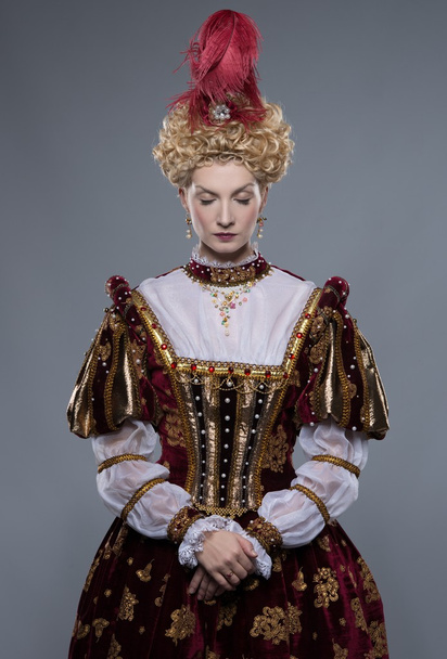 Haughty queen in royal dress isolated on grey - Photo, Image