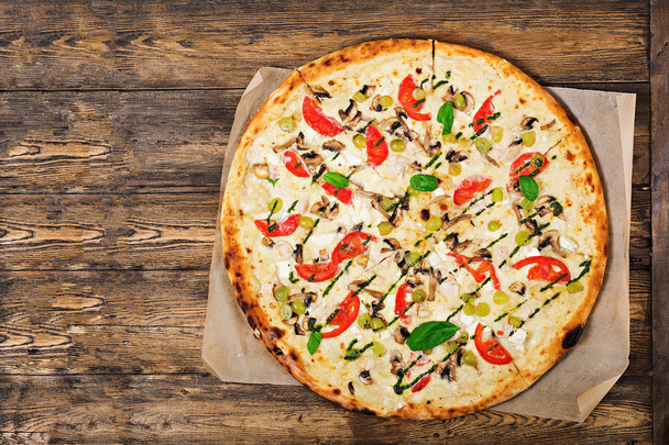 Pizza met tomaten, mozzarella, champignons en basilicum pesto. Pizza "Caprese". Italiaans eten. Bovenaanzicht. Plat leggen - Foto, afbeelding