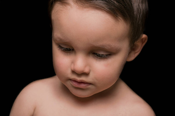 Portrait of beautiful little boy portrait on black background - Photo, Image