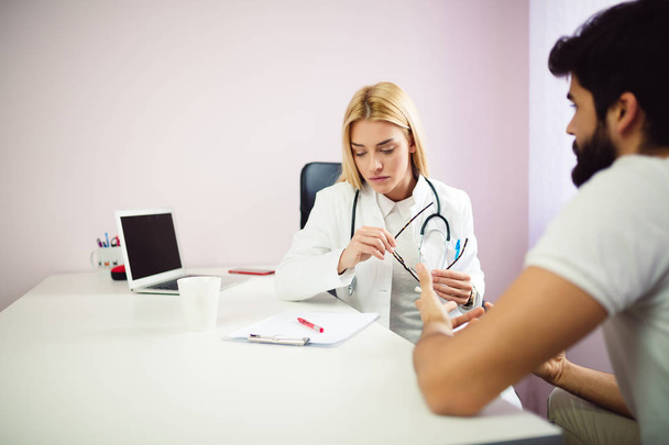Female doctor at medical office discussing results with patient - 写真・画像