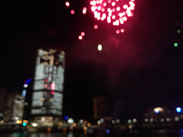 Scena astratta sfocata di fuochi d'artificio lungo il fiume nel centro della città a
 - Foto, immagini
