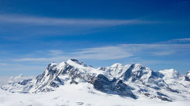 Πανόραμα ορεινό τοπίο στις Ελβετικές Άλπεις κοντά σε Zermatt σε μια όμορφη μέρα στα τέλη του χειμώνα κάτω από ένα καταγάλανο ουρανό - Φωτογραφία, εικόνα