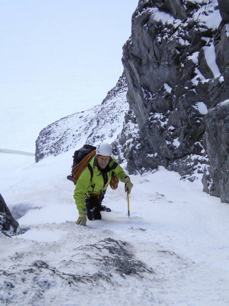 un alpiniste masculin remontant un ravin de neige escarpé et un couloir tôt le matin en route vers un sommet alpin élevé en Suisse
 - Photo, image