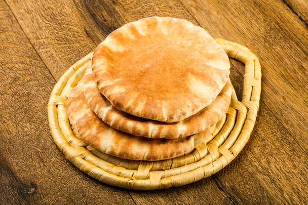 Pita bread heap over the wooden background - 写真・画像