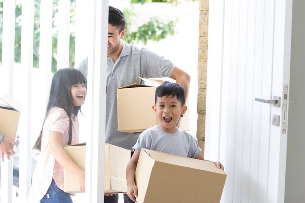 parent and kids with cardboard box. moving to new house - Foto, Imagem