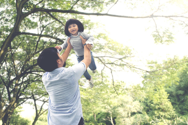 Criança brincando com seu pai no parque
 - Foto, Imagem