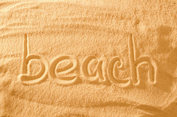 Word beach in the sand against the sun. concept symbol of holiday. - Foto, Bild