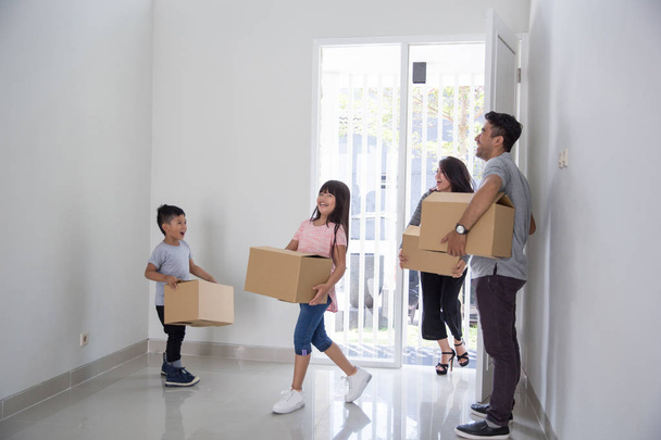 parent and kids with cardboard box. moving to new house - Valokuva, kuva