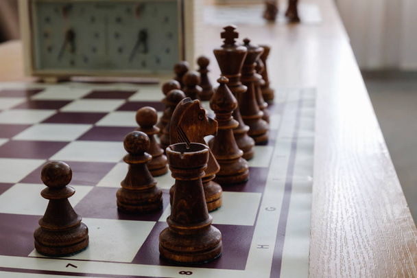 Tablero de ajedrez con piezas y reloj en escritorio de madera En relación con el torneo de ajedrez
. - Foto, Imagen