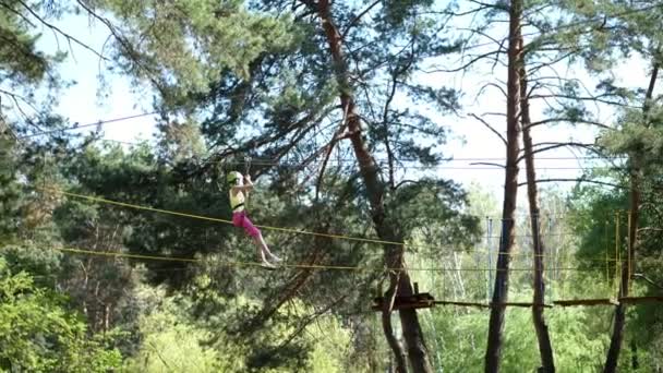CHERKASA, UKRAINE-MAY 1, 2018: pine city adventure park, Hanging rope bridges suspended between trees, Children in protective helmets and with insurance ride and climb there. - Πλάνα, βίντεο