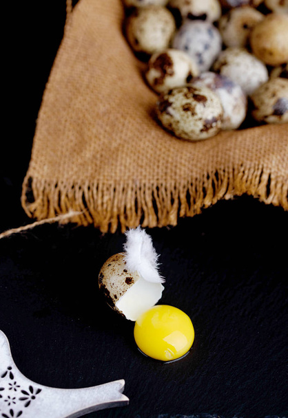 Αυγό ορτυκιού με φτερό κοτόπουλου στο τραπέζι - Φωτογραφία, εικόνα