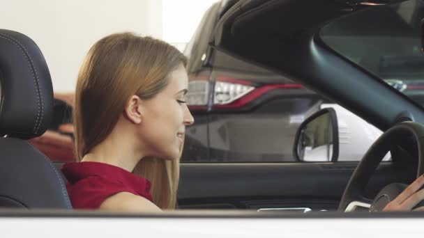 Preciosa mujer posando en su nuevo convertible sosteniendo llaves del coche
 - Imágenes, Vídeo