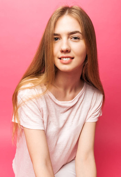 Portrait of a beautiful young girl standing on pink background l - Fotografie, Obrázek