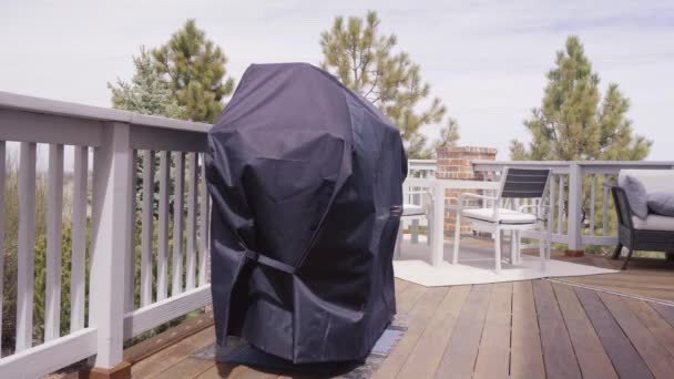 Large gas grill covered with black cover to protect from weather elements - Footage, Video