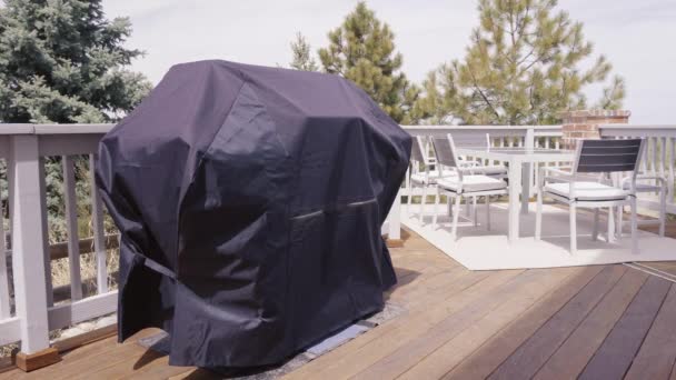 Gran parrilla de gas cubierta con cubierta negra para proteger de los elementos meteorológicos
 - Imágenes, Vídeo