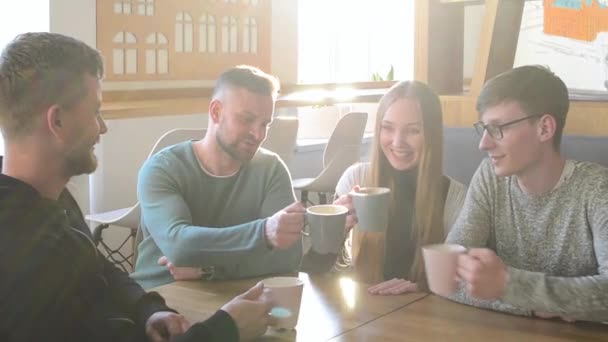 Groupe heureux d'amis ou de collègues d'affaires buvant du café et riant et utilisant l'ordinateur ensemble dans un petit café ou un bar à vin
 - Séquence, vidéo