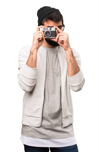 Hipster man holding a camera on white background - Zdjęcie, obraz