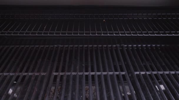 Primer plano de las rejillas de cocción de hierro fundido en la parrilla de gas exterior de seis quemadores
 - Metraje, vídeo