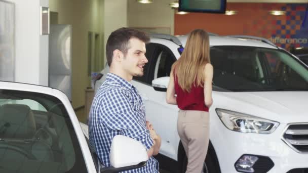 Onnellinen nuori komea mies poseeraa hänen uusi auto näyttää avaimet
 - Materiaali, video