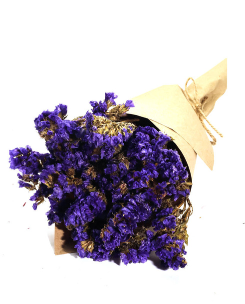 Primo piano di marrone bouquet viola statice fiore secco sul retro bianco
 - Foto, immagini