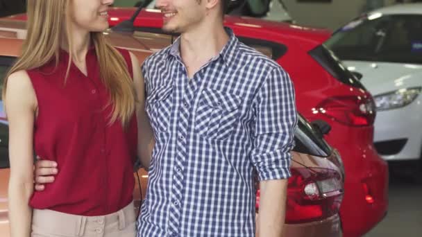 Обрізаний знімок пари посміхається, показуючи ключі від автомобіля в дилерському центрі
 - Кадри, відео