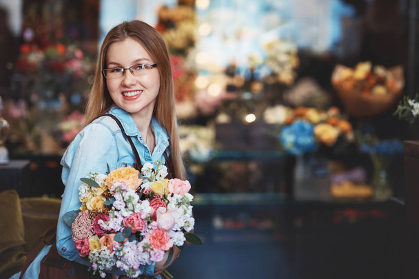 Улыбающийся флорист с букетом в магазине
 - Фото, изображение