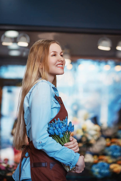 Smiling woman with muscari indoors - 写真・画像