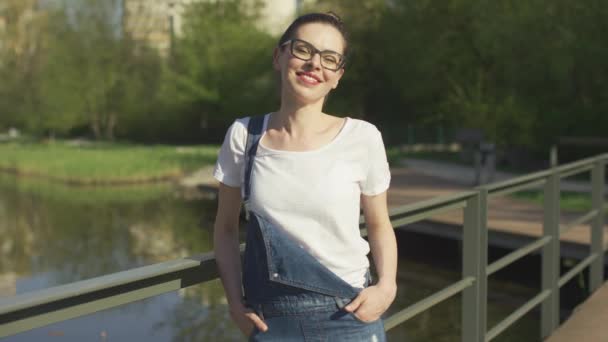 Usmívající se žena opírá se o zábradlí nad vodou - Záběry, video