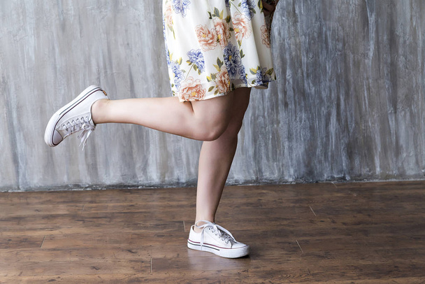 gladde vrouwelijke benen op een grijze achtergrond - Foto, afbeelding